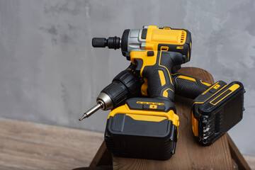 Professional cordless power tool set with yellow and black drill, impact driver, and lithium-ion...
