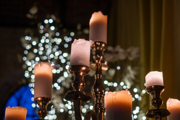 Elegant candles glowing softly in festive ambiance, surrounded by twinkling lights, creating a warm...
