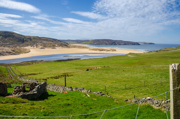 Scenic Coastal Landscape of Northern Scotland with Green Fields and Blue Sky