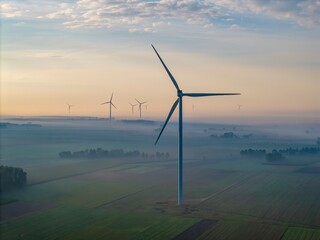 Aerial view of a windmill farm on a foggy autumn day, with beautiful light and colours, a unique...