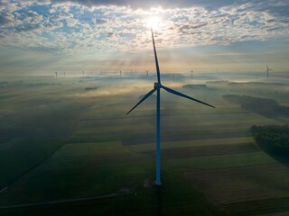 Aerial view of a windmill farm on a foggy autumn day, with beautiful light and colours, a unique...