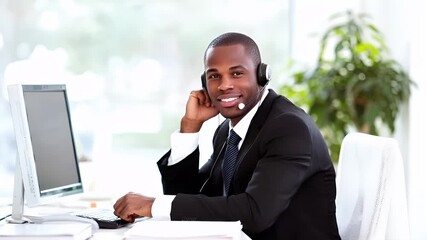 Customer support service representative agent. A man in a suit with a headset in a call center setting. He is smiling and appears to be engaged in a pleasant conversation.