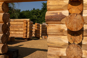 Close-up of a log house under construction. Intricate joinery of natural wooden logs highlights...