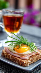 Delicious breakfast: whole-wheat toast, ham, fried egg topped with fresh dill & chives, paired with a hot cup of tea for a bright morning.