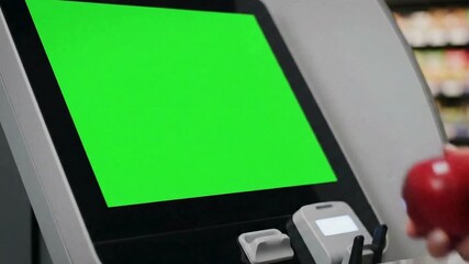 Woman's Hand Holding Red Apple Near Green Screen Display in Store