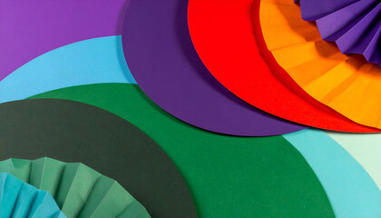 Obraz premium An overhead shot of colorful semi-circles and folded paper fans arranged in a vibrant, overlapping pattern.