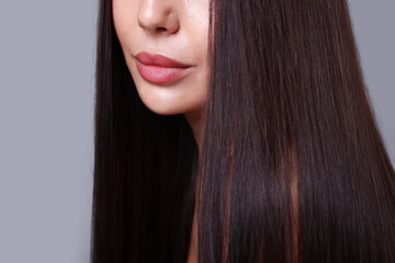 Naklejka premium Woman with beautiful smooth hair after lamination procedure on light grey background, closeup