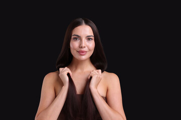 Obraz premium Woman with beautiful smooth hair after lamination procedure on black background, space for text
