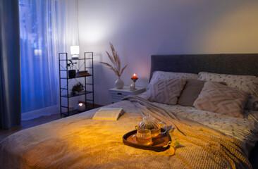 cup of tea on cozy bed with autumn decorations