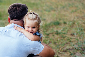 Father hugging little daughter outdoors in countryside authentic family lifestyle