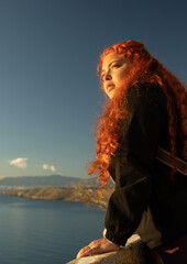 Woman contemplating the Mediterranean Sea while receiving the warm light of the sunset, relaxing...