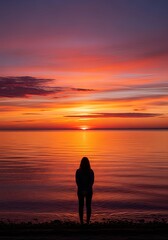 Fototapeta premium Serene Cinematic Sunset over Calm Water with Person Standing on Shore Symbolizing Reflection and Peace