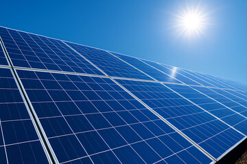 Obraz premium Low-angle view of solar panels with sunlight reflections under vivid blue sky