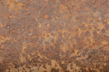 Old metal surface completely covered with brown-orange rust with rough texture and spots as...