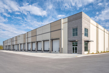 Obraz premium Modern warehouse building with loading docks under a bright sky