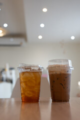 Thai iced lemon tea and iced coffee mocha on wood table at cafe