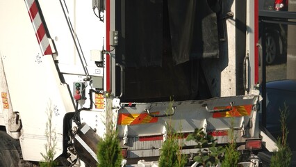 Śmieciarka pod altaną śmietnikową odbierająca śmieci © tomo81