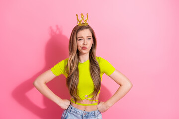 Lovely young girl wearing bright neon yellow top with a shiny crown, posing with a pouty facial...