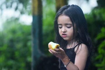 little girl holding half eaten apple, health and nutrition concept.