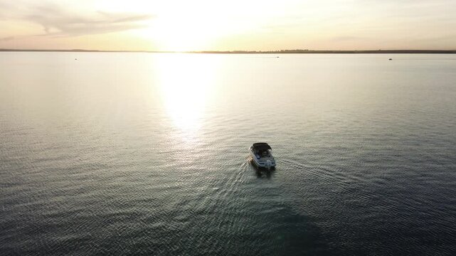 Imagens de uma lancha no rio ao por do sol feitas por drone