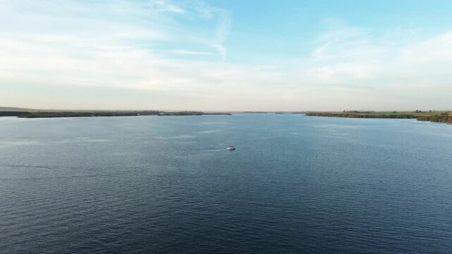 Imagens de uma lancha no rio ao por do sol feitas por drone