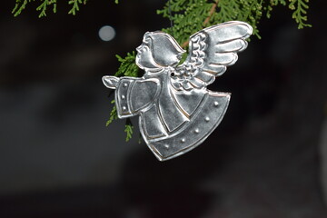 little silver angel praying pending from a christmas tree