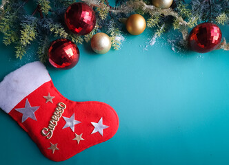 green background with gold and red Christmas balls and pine branch and Santa's boot and with space for text