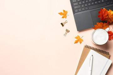 Autumn office desk. Laptop, notebook, coffee cup and yellow leaves.