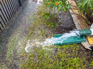 Rainwater gushing from downspout on house during a thunderstorm