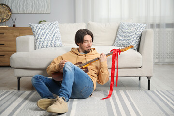 Dreams come true. Happy man with guitar at home
