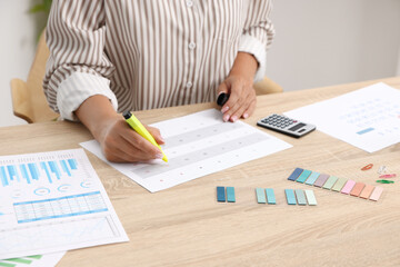 Business planning. Woman with calendar at wooden table in office, closeup