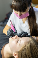 Expert applying lip permanent makeup for long-lasting enhancement in a beauty treatment session