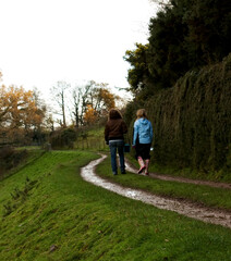Fototapeta premium Two people walking on a muddy path