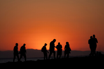 Fototapeta premium Silhouettes of People Enjoying a Sunset by the Sea Side, Antalya