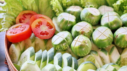 Fresh Indonesian vegetables with sliced tomato, eggplant, cucumber, and lettuce for traditional...