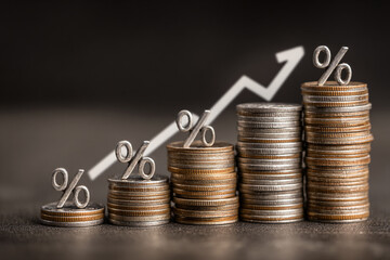 Rising interest rates shown with coins and upward trending graph