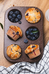 Blueberry muffins on a rustic table in a mold
