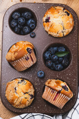 Blueberry muffins on a rustic table in a mold