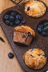 Blueberry muffins on a rustic table in a mold