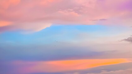 Dramatic pastel sunset sky with clouds in huesc A pink. i orange, purple, and blue. The vibrant colors create a serene, romantic, and dreamy abstract background.