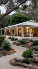 Beautiful modern house surrounded by lush greenery and a winding pathway during twilight hours creates a peaceful atmosphere in nature