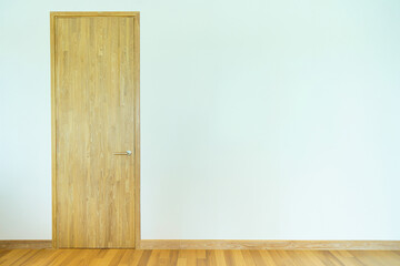 Wooden door in white room with wooden floor, minimalist interior design.