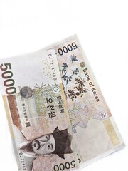 Two South Korean 5,000 won banknotes are isolated on a white background. Front and back of 5,000 won. South Korean won, also called the Republic of Korea won, is the official currency of South Korea.