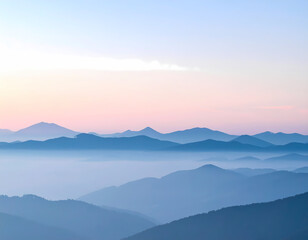 Obraz premium Serene mountain landscape at sunrise with blue hazy fog in valley. calm morning light creates peaceful and beautiful view over layered mountain range. tranquil scene