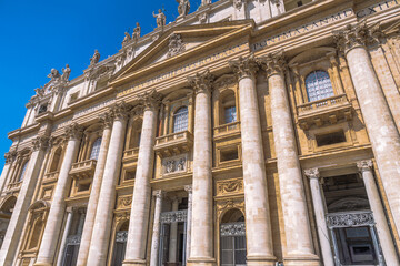 Architectural grandeur of a building with majestic columns and intricate details under a clear blue sky, showcasing timeless design.