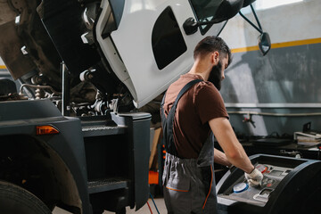 Auto mechanic repairing truck air conditioning system in garage