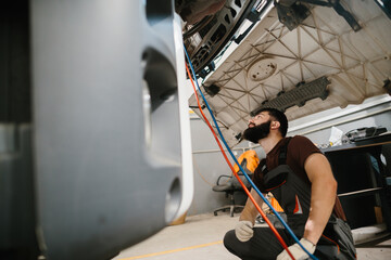 Auto mechanic inspecting truck in repair shop