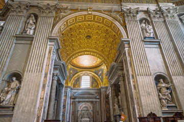 Cathedral interior view showcasing ornate sculptures, columns, and a gilded dome, blending artistry...