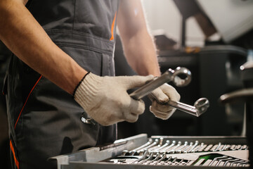 Auto mechanic choosing right wrench for repairing trucks