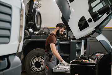Mechanic picking tools for repairing truck in garage